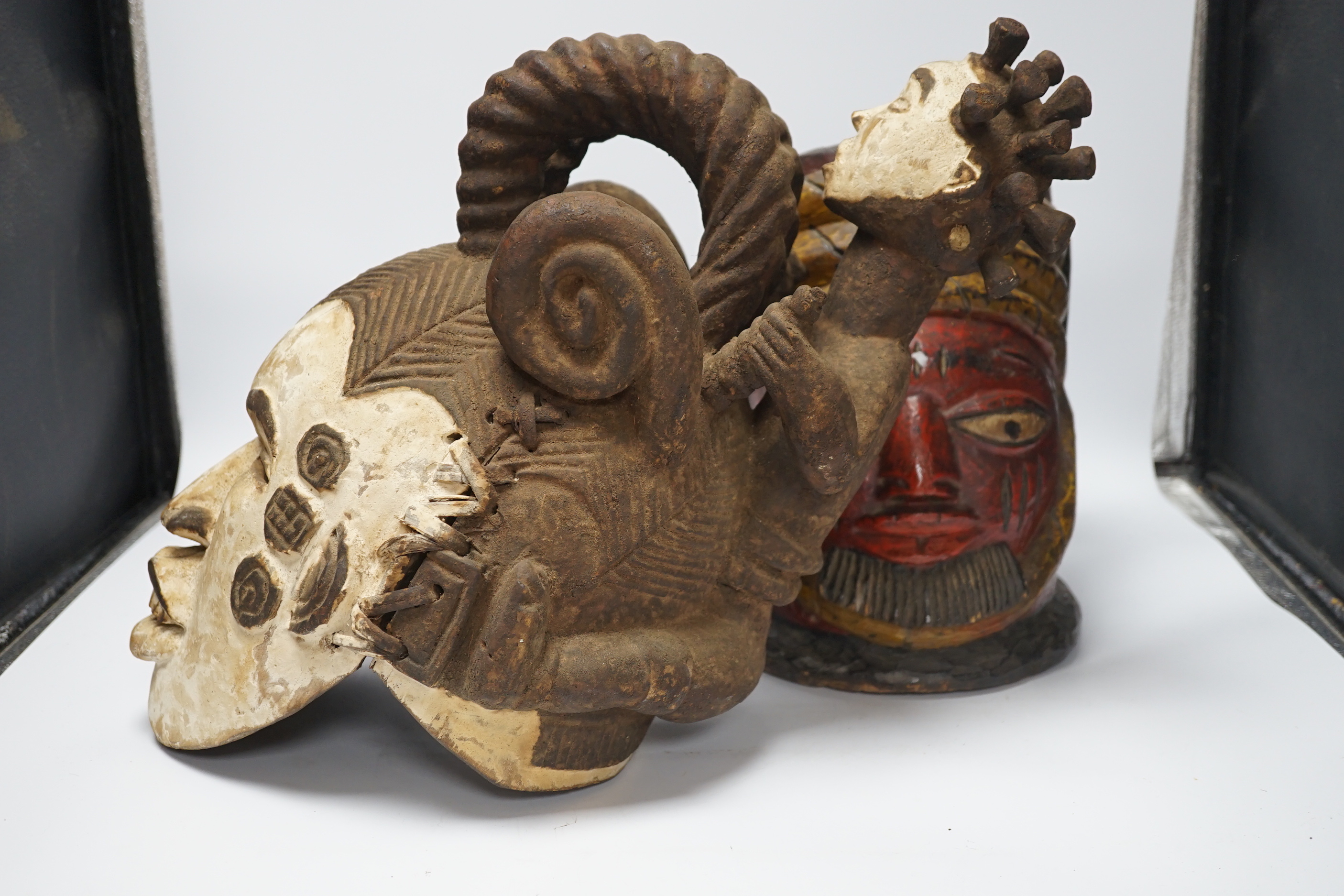 An Igbo maiden spirit mask and an African tribal helmet mask, largest 46cm wide